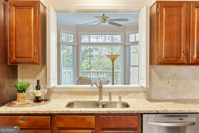 kitchen with dishwasher, crown molding, a sink, and brown cabinets