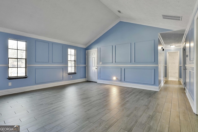 foyer entrance featuring light wood-style floors, plenty of natural light, a decorative wall, and a textured ceiling