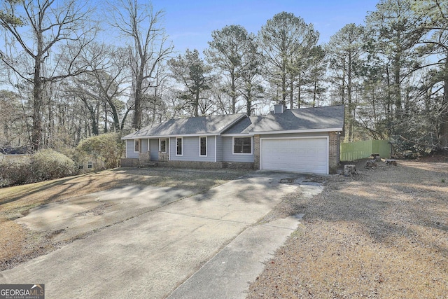 ranch-style home featuring concrete driveway, fence, a chimney, and an attached garage