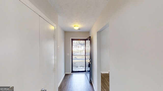 entryway with baseboards, dark wood finished floors, and a textured ceiling