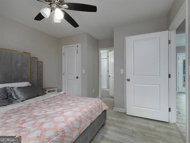 bedroom with light wood-type flooring, baseboards, and a ceiling fan