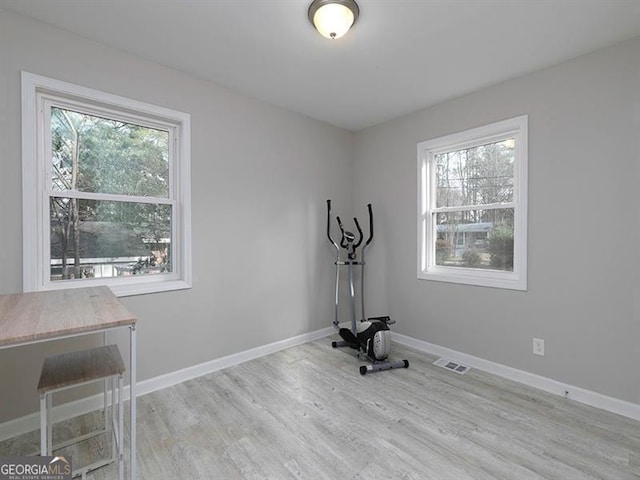 workout room with visible vents, baseboards, and wood finished floors