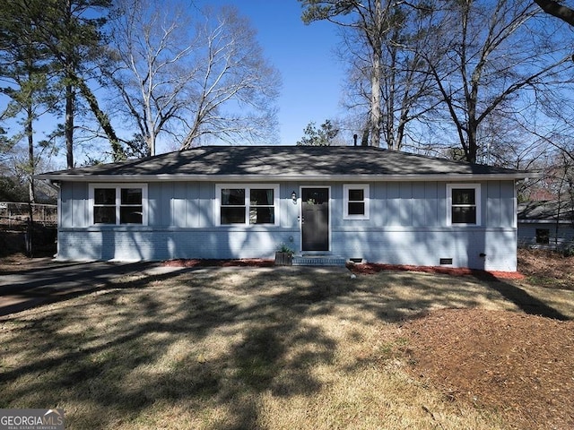 view of front facade with entry steps, brick siding, crawl space, a front lawn, and board and batten siding