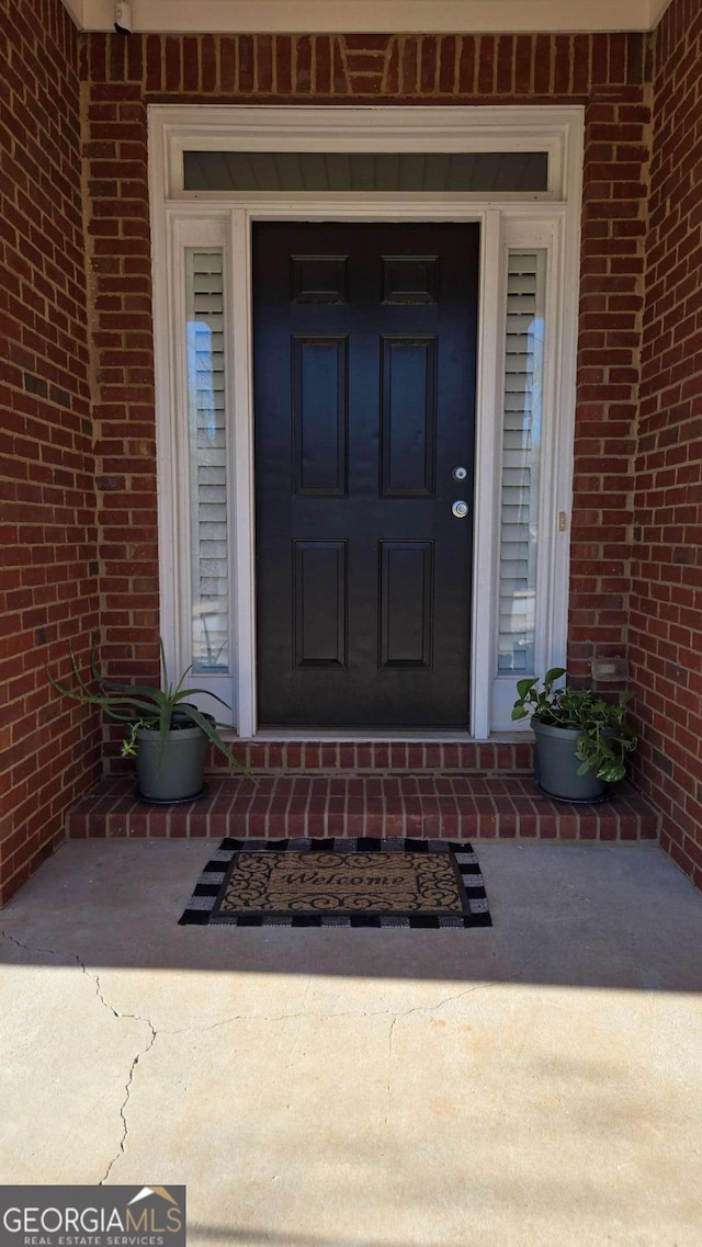 view of exterior entry with brick siding