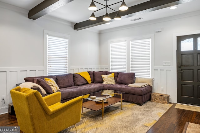 living room with visible vents, beam ceiling, wood finished floors, and a wainscoted wall