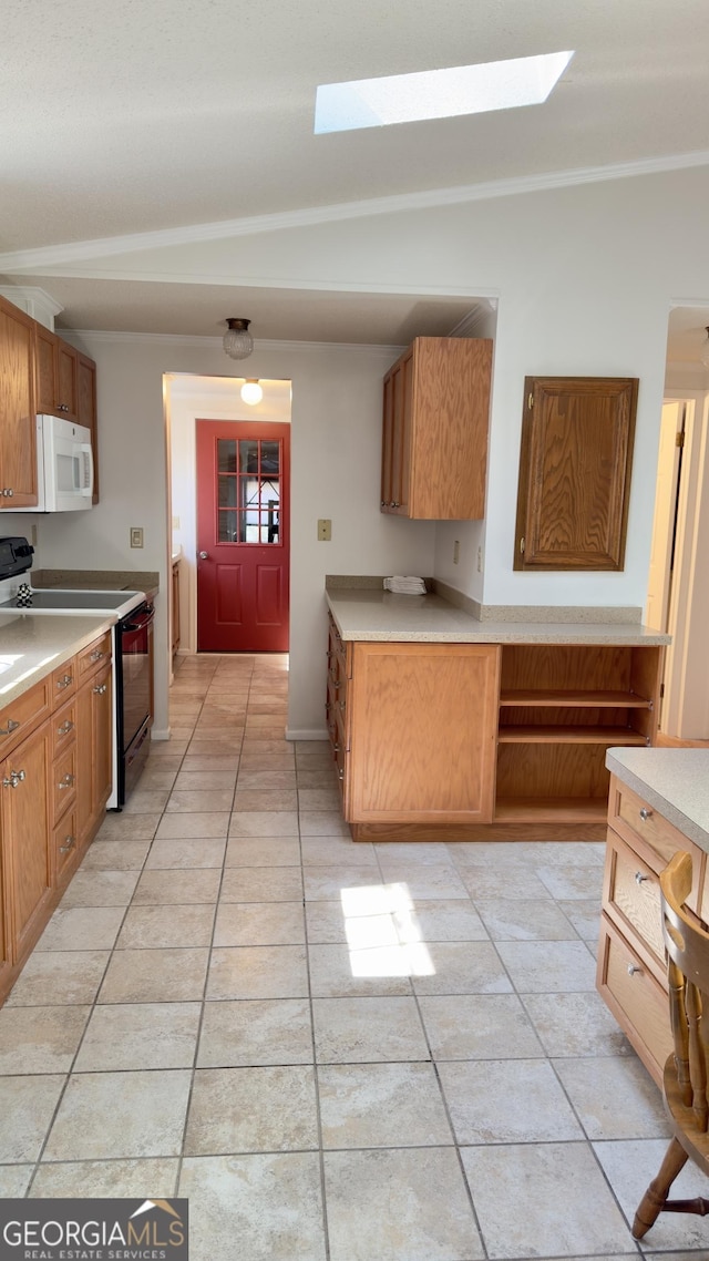 kitchen featuring black electric range, white microwave, light countertops, and brown cabinetry