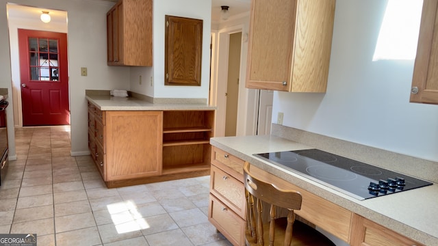 kitchen featuring light countertops, brown cabinetry, and black electric cooktop