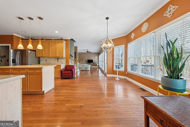 kitchen with light wood finished floors, visible vents, stainless steel fridge with ice dispenser, open floor plan, and light countertops