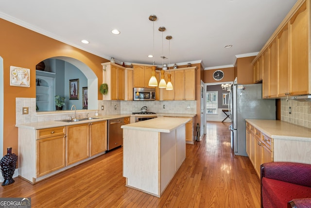 kitchen featuring stainless steel appliances, a kitchen island, a sink, light countertops, and light wood-type flooring