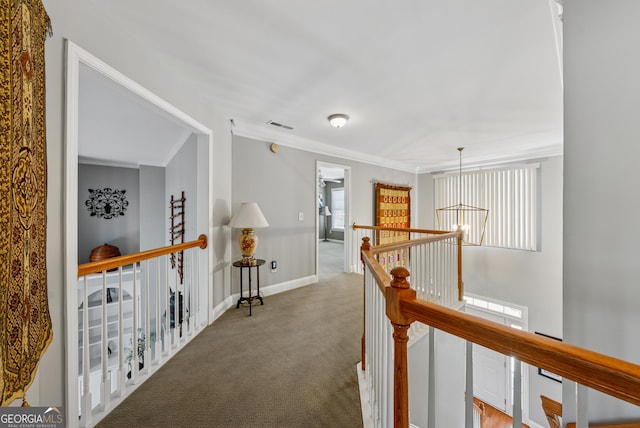 corridor featuring visible vents, baseboards, an upstairs landing, carpet, and crown molding