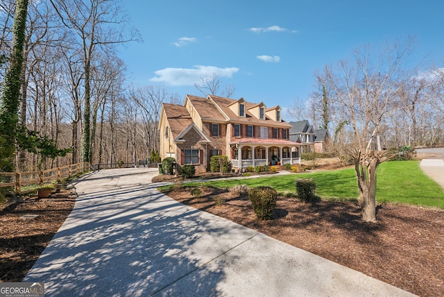 view of front of home featuring fence, a porch, and a front yard