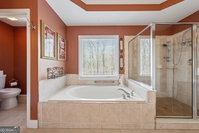 bathroom featuring a tray ceiling, a garden tub, toilet, a shower stall, and tile patterned flooring