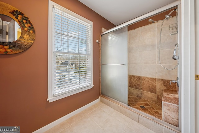 bathroom with tile patterned flooring, a shower stall, and baseboards