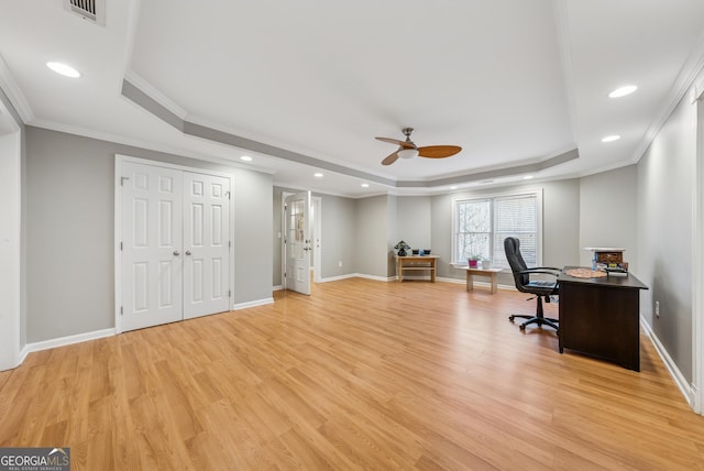 office featuring light wood-type flooring, visible vents, a tray ceiling, and baseboards