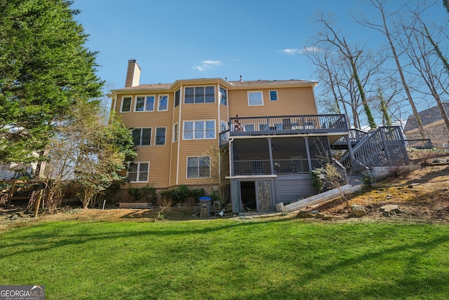 rear view of house with a deck, a yard, stairway, and a chimney