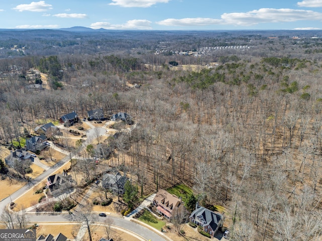 drone / aerial view with a wooded view