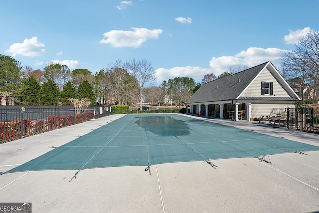 community pool with a patio and fence