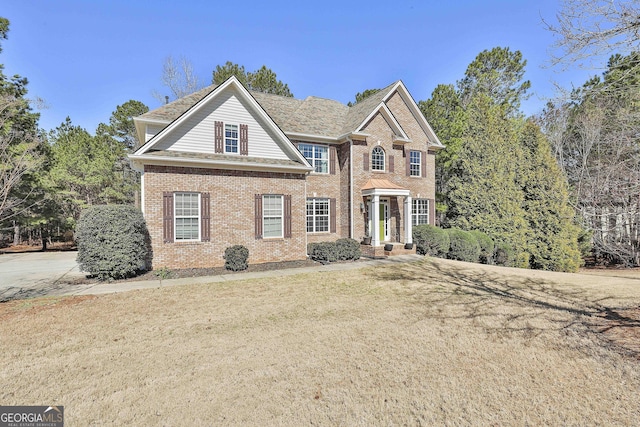 view of front of property with a front yard and brick siding