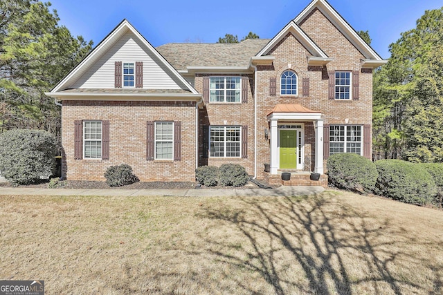 view of front of house featuring brick siding and a front lawn