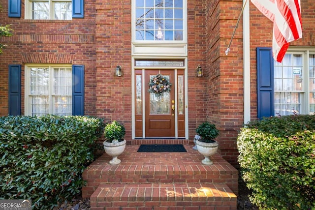 doorway to property featuring brick siding