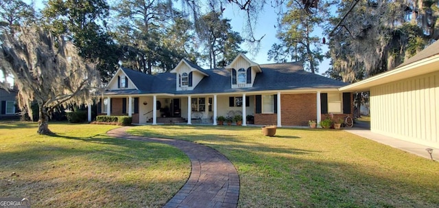 view of front of house with covered porch, brick siding, and a front lawn