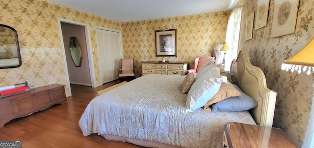 bedroom featuring wallpapered walls and wood finished floors