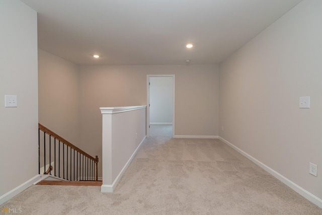 hallway with recessed lighting, baseboards, light carpet, and an upstairs landing