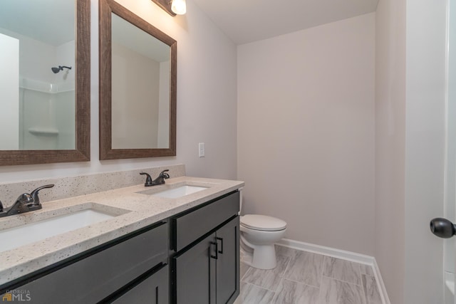 full bathroom with toilet, double vanity, a shower, and a sink