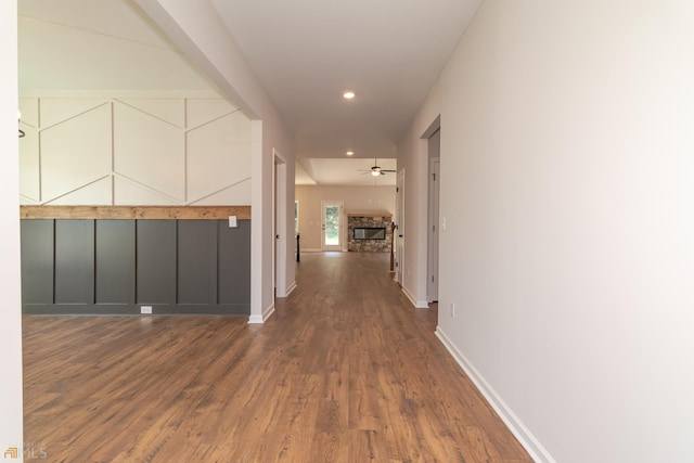 corridor with dark wood-style floors, baseboards, and recessed lighting