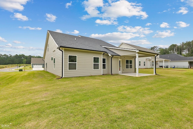 rear view of property featuring a patio area, a lawn, and roof with shingles