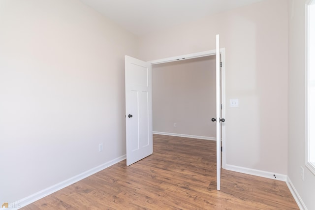 unfurnished room featuring baseboards and wood finished floors