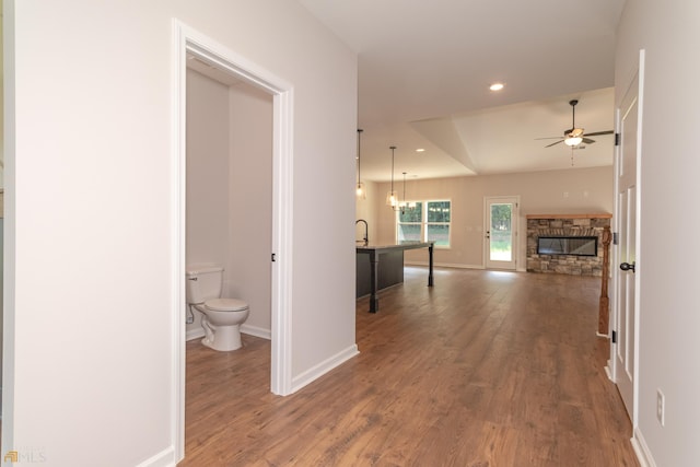 hall featuring recessed lighting, wood finished floors, and baseboards