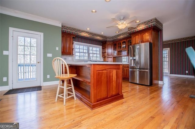 kitchen featuring a kitchen breakfast bar, light countertops, stainless steel fridge with ice dispenser, open shelves, and glass insert cabinets