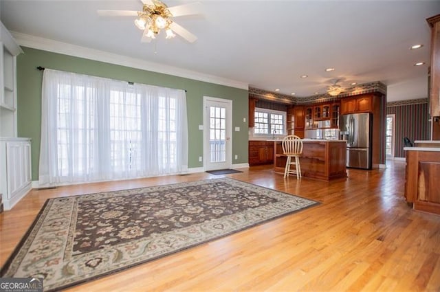kitchen with a center island, stainless steel fridge, a kitchen bar, and wood finished floors