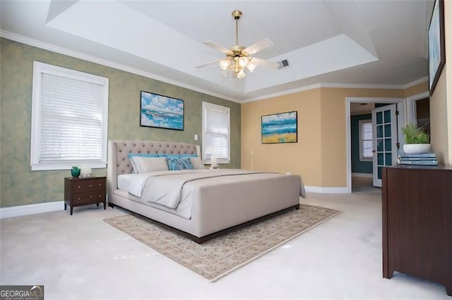carpeted bedroom with wallpapered walls, baseboards, and a raised ceiling