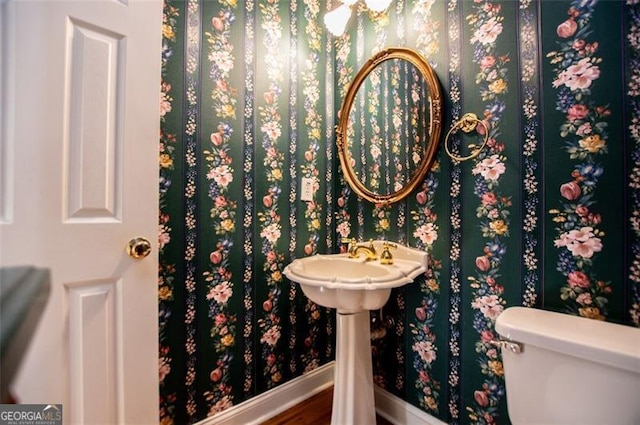 bathroom with toilet and baseboards