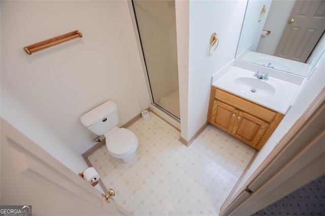 bathroom featuring toilet, vanity, baseboards, tile patterned floors, and a stall shower