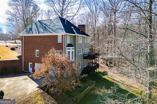 view of side of property featuring brick siding and a chimney
