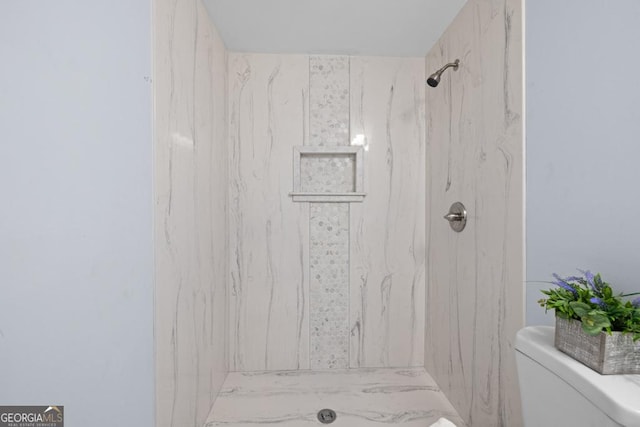 full bathroom with a marble finish shower and toilet