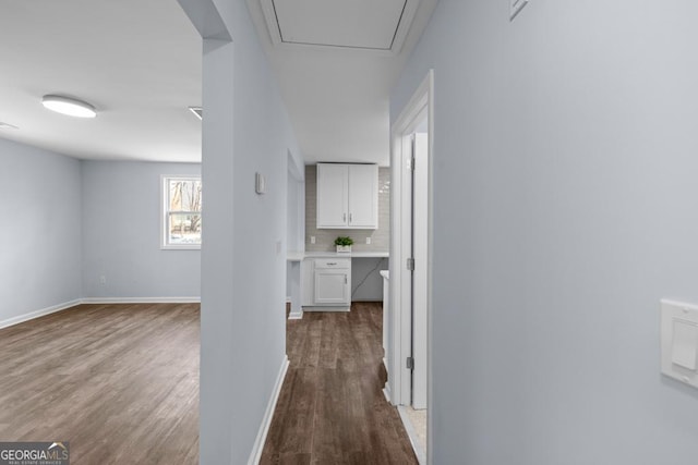 hallway featuring baseboards and wood finished floors