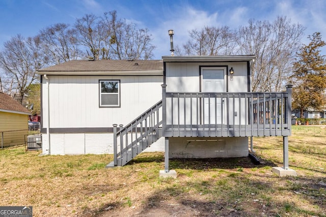 rear view of house featuring a yard and a wooden deck