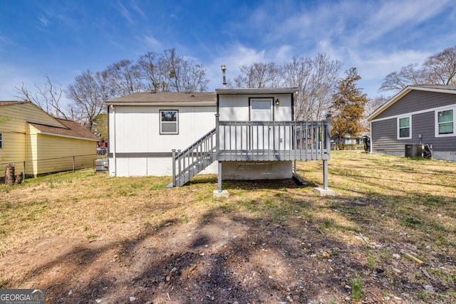 rear view of house featuring a lawn, a wooden deck, fence, and stairs