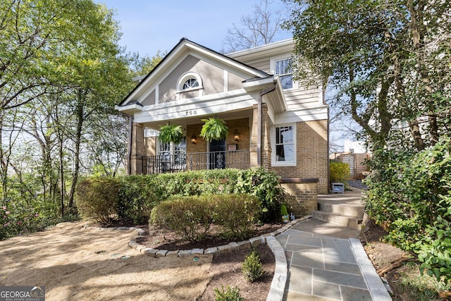 view of front of home with covered porch and brick siding