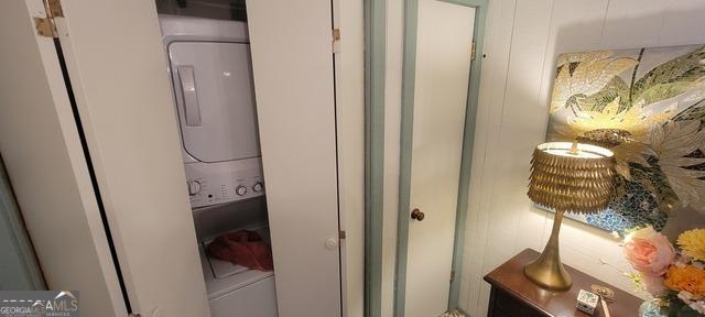 clothes washing area featuring laundry area and stacked washer / dryer