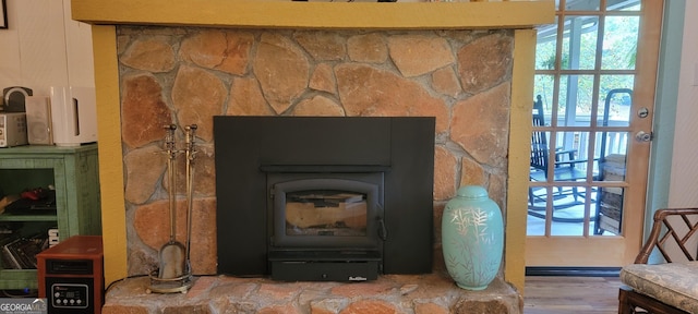 interior details with a wood stove and wood finished floors