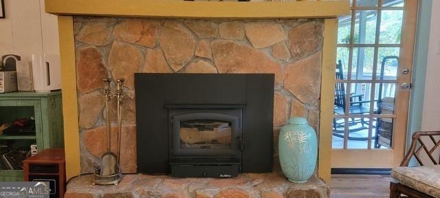 interior details featuring a wood stove and wood finished floors