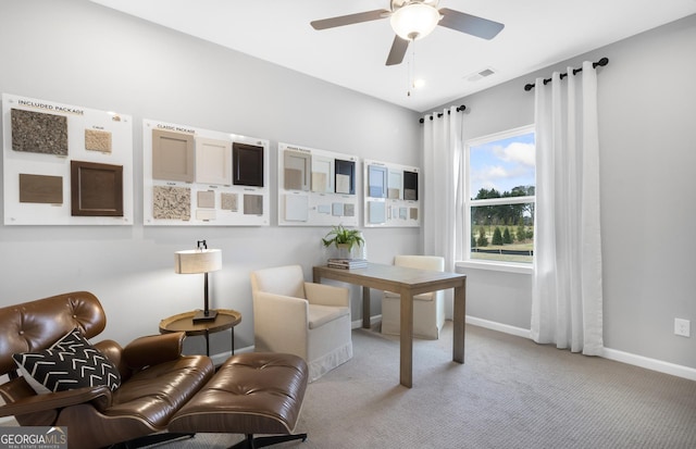 office area featuring baseboards, visible vents, a ceiling fan, and light colored carpet