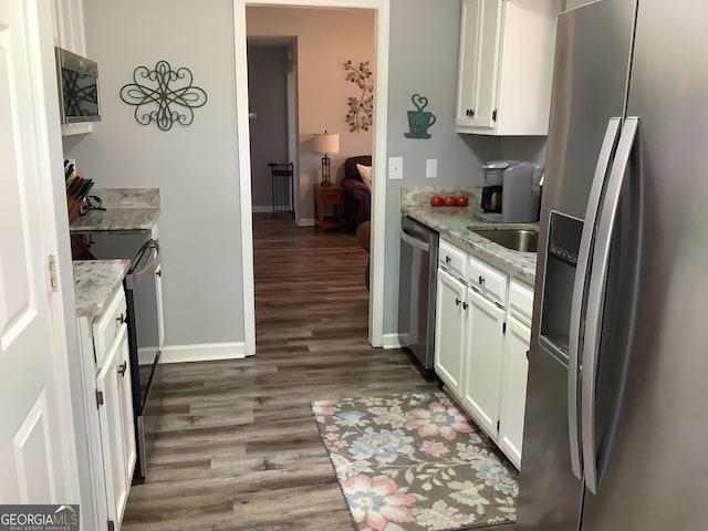 kitchen featuring stainless steel appliances, dark wood-type flooring, white cabinets, and light stone countertops