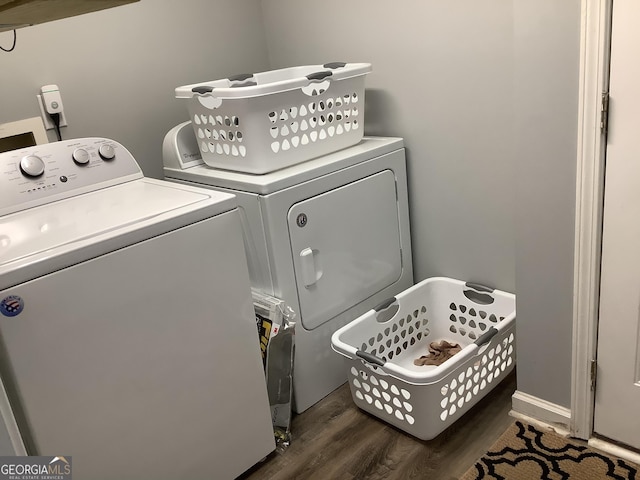 washroom with laundry area, baseboards, separate washer and dryer, and dark wood finished floors