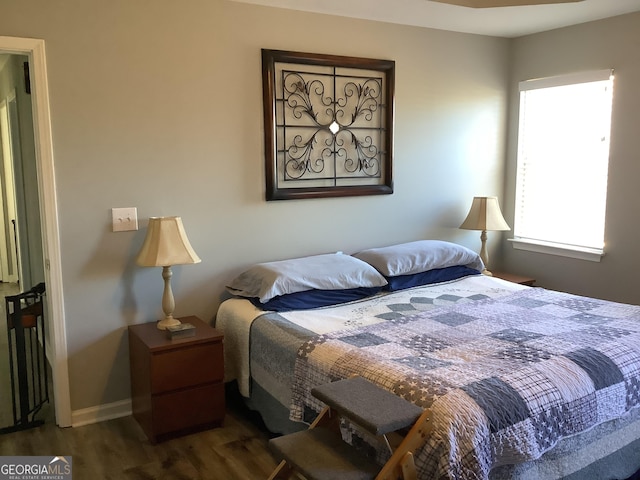 bedroom with radiator heating unit, baseboards, and dark wood-type flooring